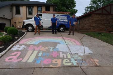 We're all in this together written on the floor with three people posing